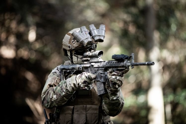 Militare in mimetica che prende la mira con fucile M16